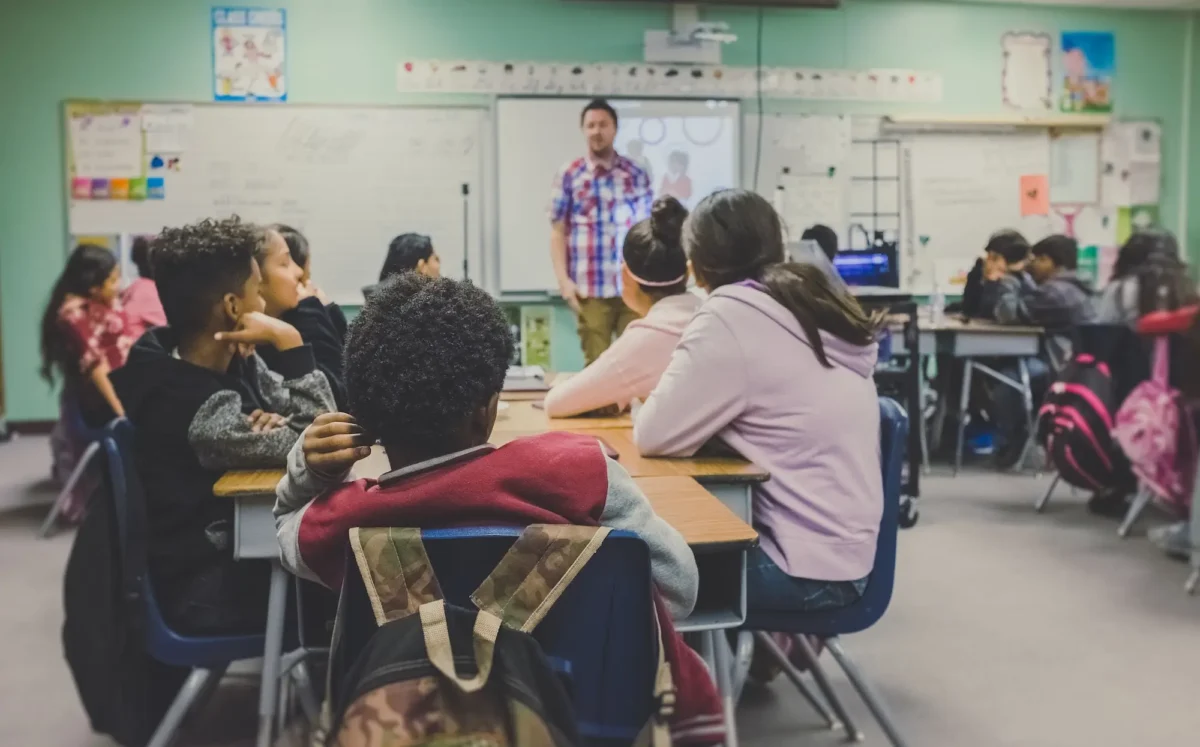 Class of kids listening to a teacher.